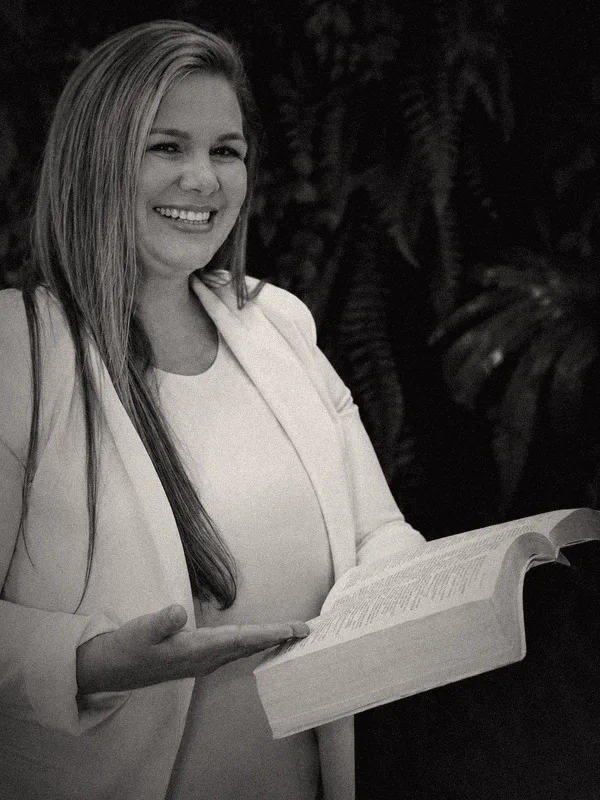 Viviane sorrindo, com uma Bíblia aberta na mão.