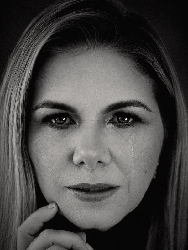 Retrato de Viviane adulta, em preto e branco, com uma lágrima no rosto.